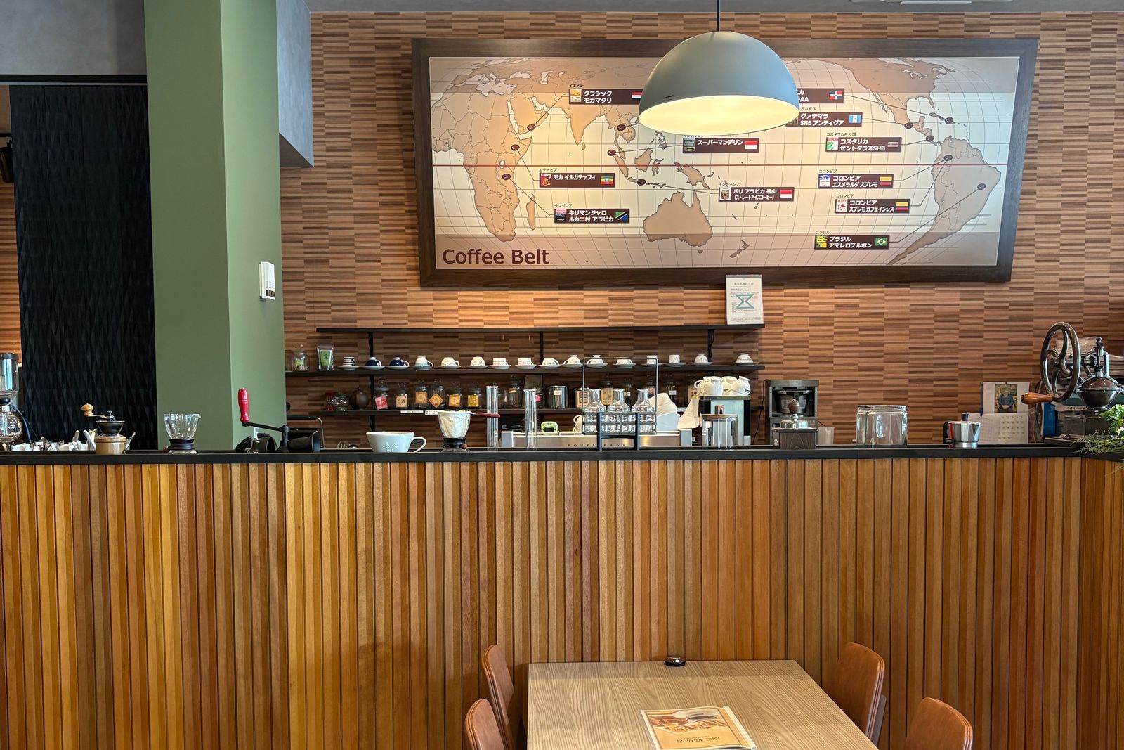 コーヒーベルトの地図が飾られたカウンターとテーブル席